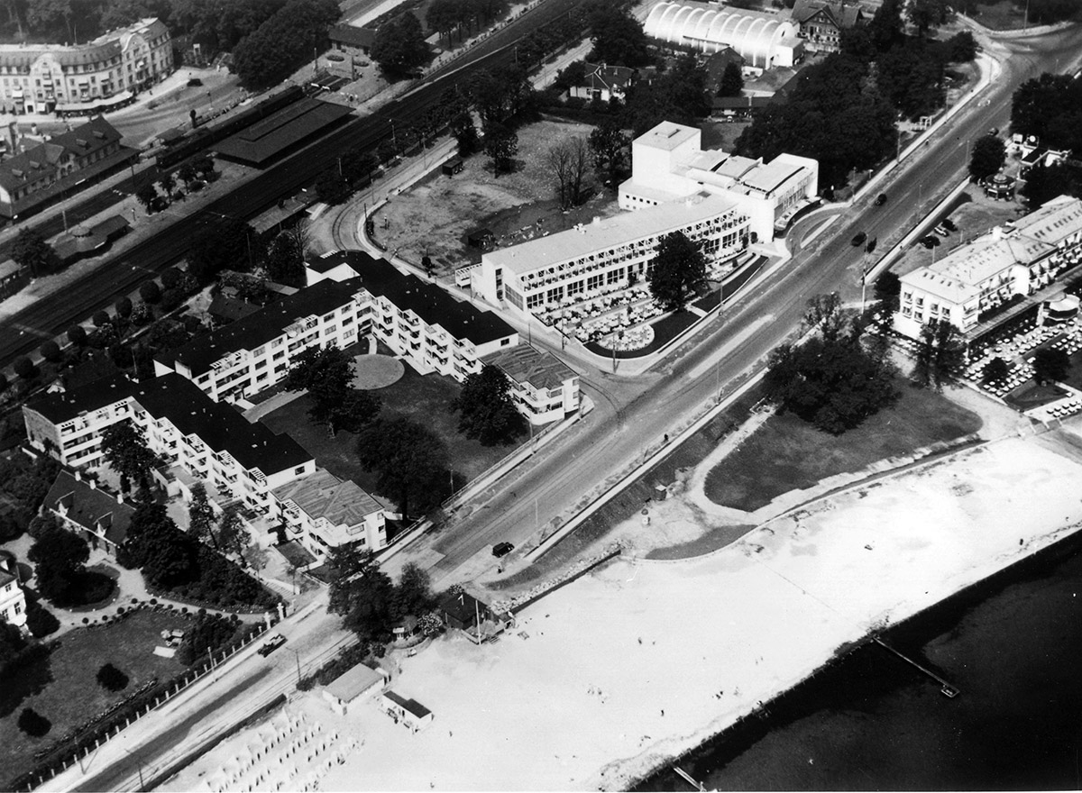 Conjunto de edificios terminados en la playa Bellevue en 1937. De izquierda a derecha apartamentos ‘Bellavista’ (1931-34), Restaurante y Teatro ‘Bellevue'(1935-37) y escuela de hípica ‘Mattsson’ (1933-34). El club de piragüismo se contruiría al año siguiente justo frente al bloque residencial. El antiguo Hotel de la Playa aún permanecía flanqueando el acceso al recinto de la playa (derecha).