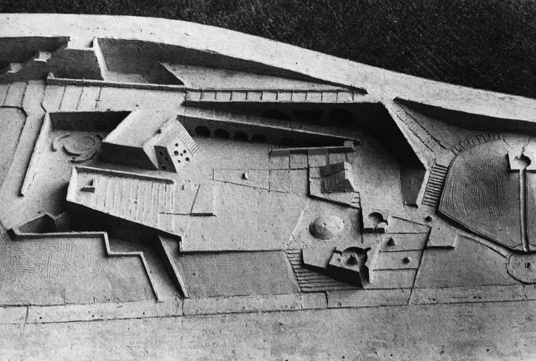 Fotografía en blanco y negro de una maqueta de relieve de escayola del Playground Adele Levy: un terreno modelado con plataformas, rampas, escalinatas, hondonadas y formas geométricas excavadas.